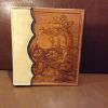 bronc rider with floral carving on a photo album cover